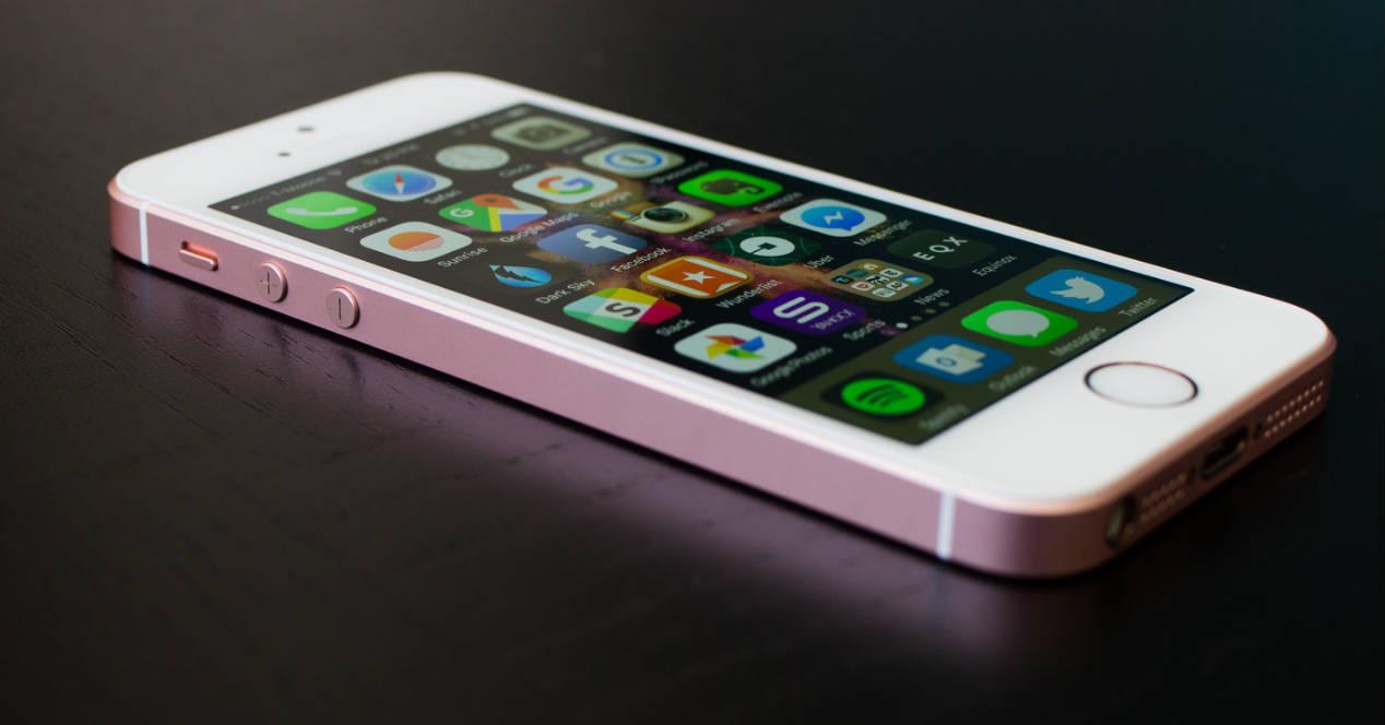 iPhone SE rosa en mesa negra
