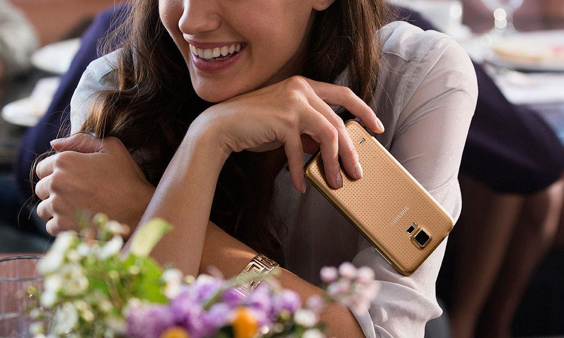 Chica con un Samsung Galaxy S5 en oro