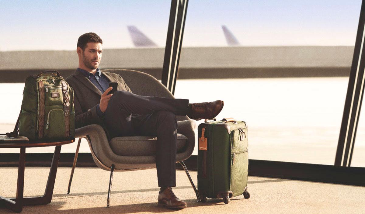 Hombre esperando avión en aeropuerto con maletas