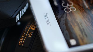 Movil Honor junto a cámara reflex