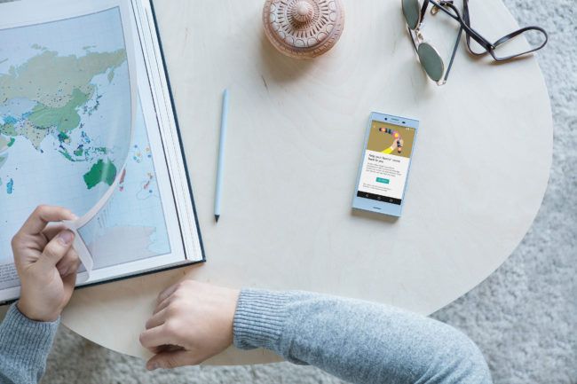 Sony Xperia Compact blanco sobre una mesa y al lado de un ordenador