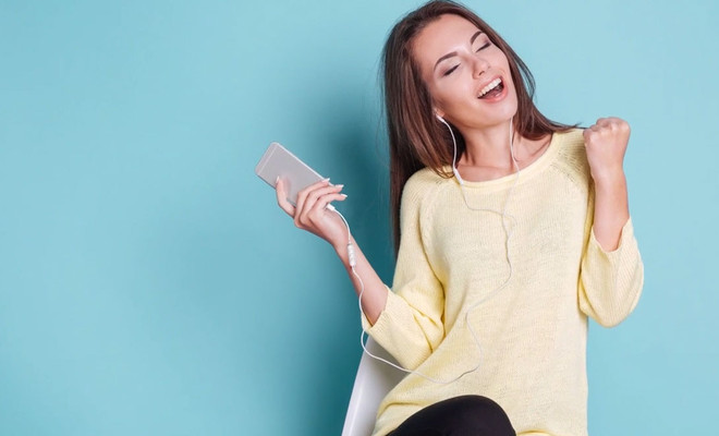 mujer con iphone y amp.i.am para sus auriculares