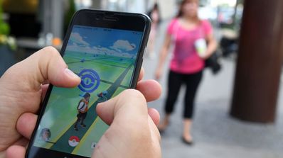 movil en la mano cazando pokémon por la calle
