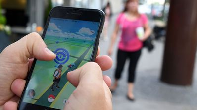 movil en la mano cazando pokémon por la calle