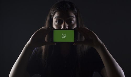 whatsapp en manos de mujer a oscuras