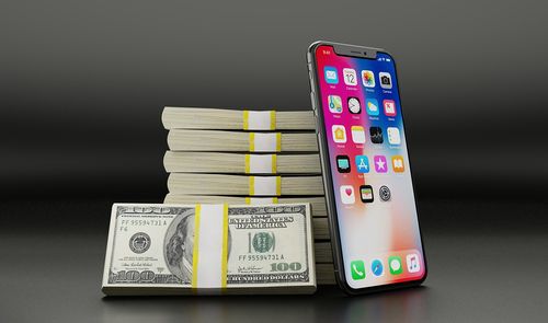 iPhone X junto a billetes de dolar