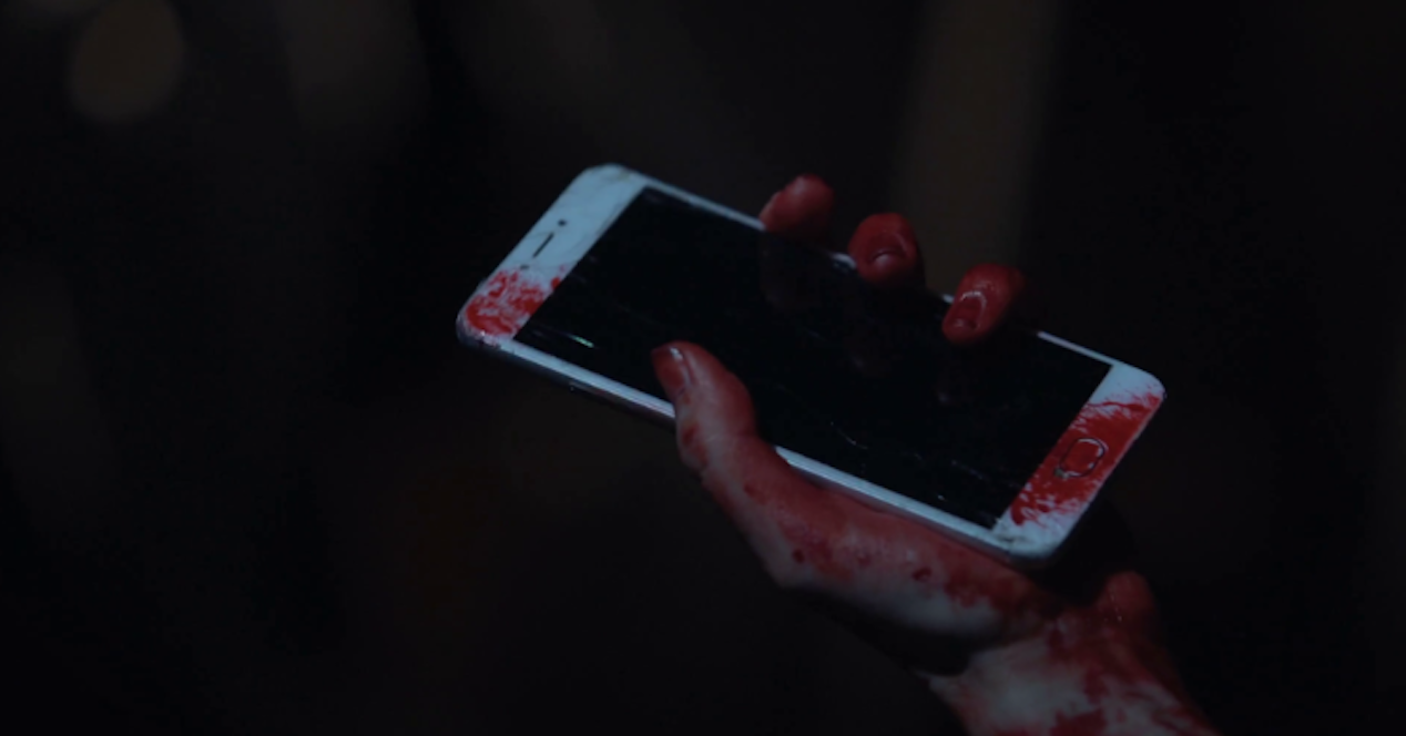 smartphone en mano con sangre