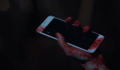 smartphone en mano con sangre