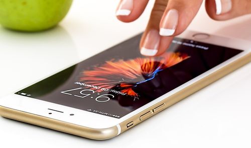 dedos tocando la pantalla del iPhone