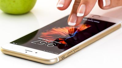 dedos tocando la pantalla del iPhone