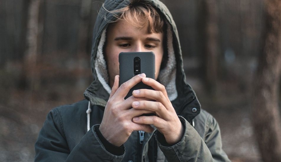 niño con oneplus en la mano