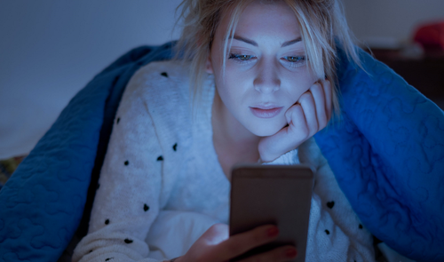 chica con movil en la cama