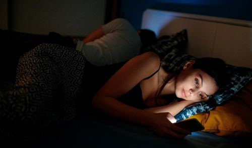 chica con movil en la cama