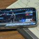 iPhone con el juego NBA Infinite en pantalla sobre cuaderno con tácticas de basket