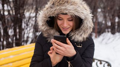 chica usando móvil nieve