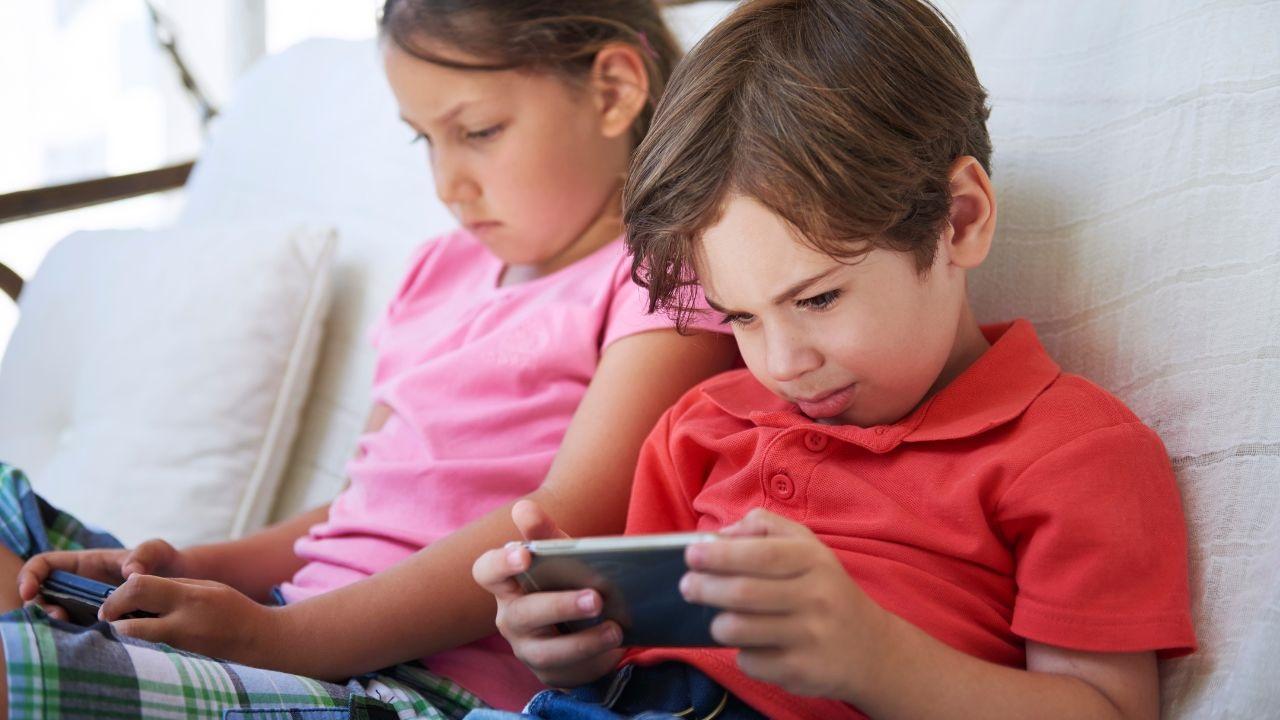 Niños jugando Smartphone / niño niña mantenga el teléfono en la