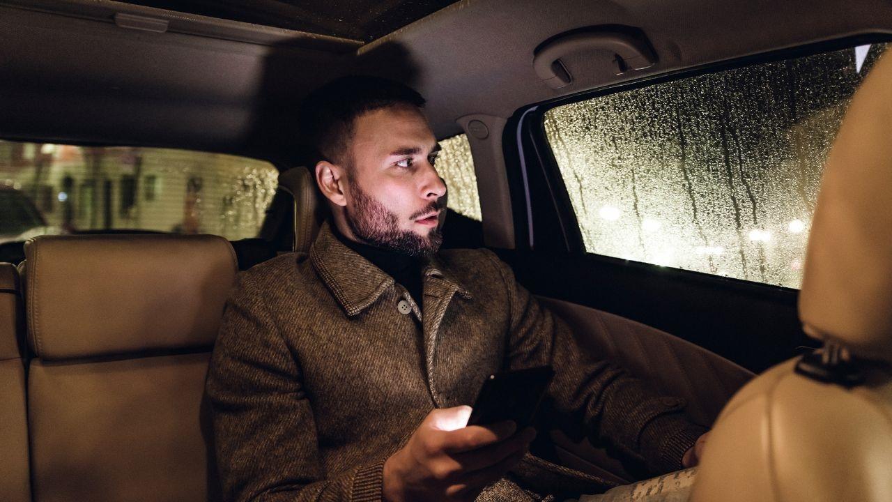 hombre dentro de un coche con móvil uber