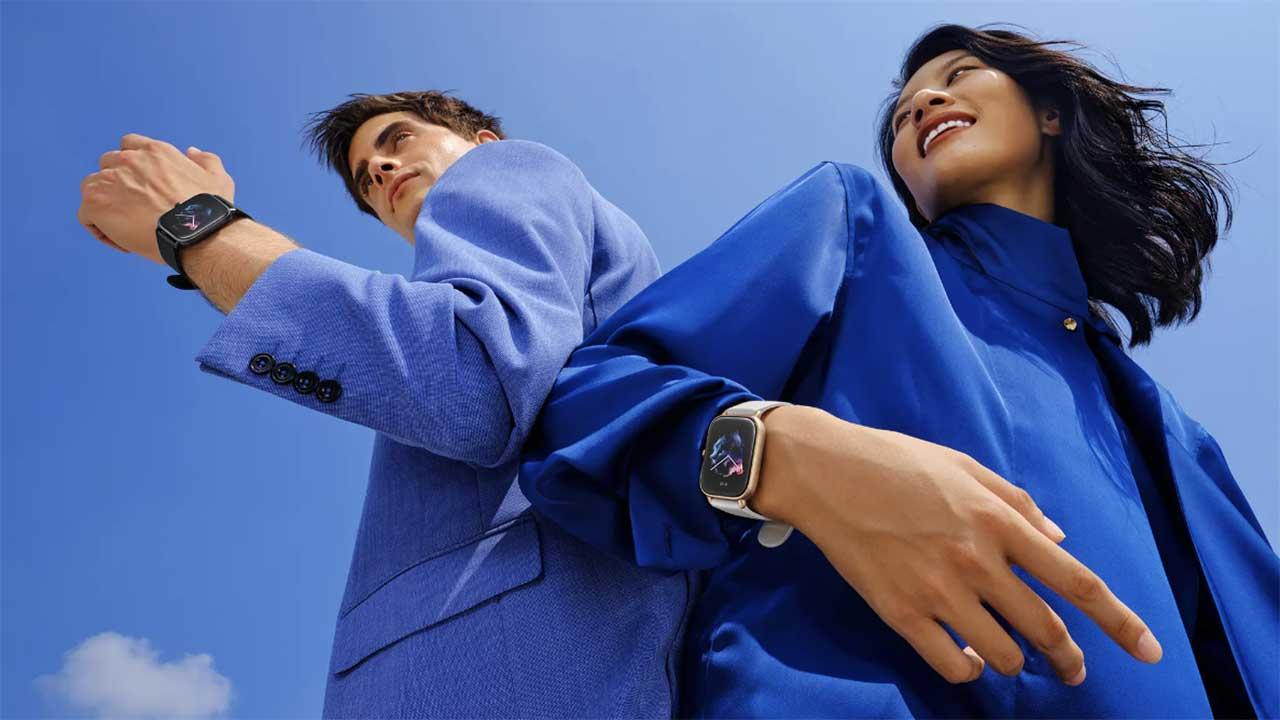 Amazfit GTS 3 en mano cpn personas vestidas de azul