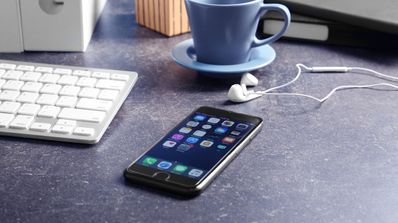 iphone 8 apoyado mesa ordenador taza cafe