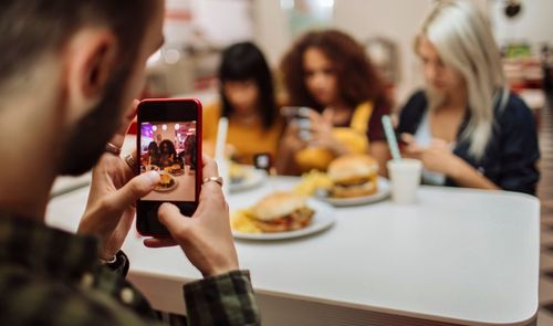 chico haciendo foto personas comiendo