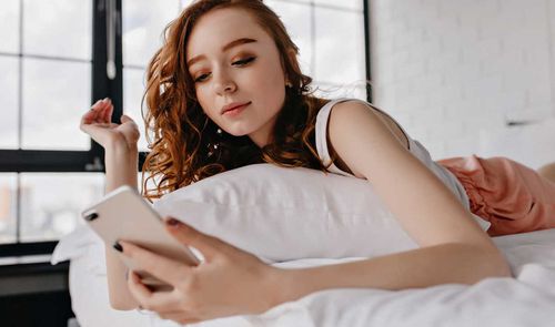 mujer con movil en cama
