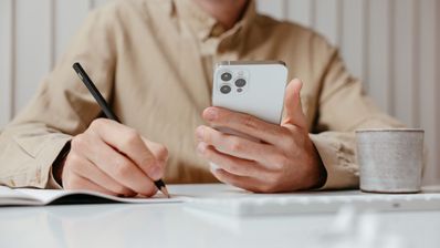 persona con móvil y tomando notas