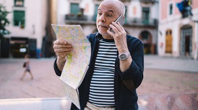 hombre haciendo llamada con mapa en mano