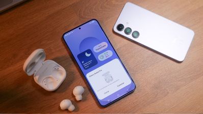 Teléfono Samsung Galaxy S25 mostrando la interfaz de conexión con auriculares inalámbricos Galaxy Buds en una superficie de madera.