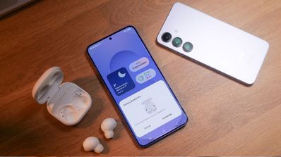 Teléfono Samsung Galaxy S25 mostrando la interfaz de conexión con auriculares inalámbricos Galaxy Buds en una superficie de madera.