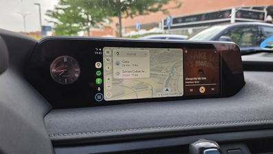 Interfaz de Android Auto con Google Maps y reproducción de música en la pantalla de un vehículo.