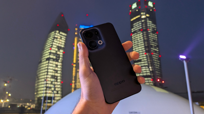 Oppo Reno 13 sujetado en la mano con fondo de Madrid