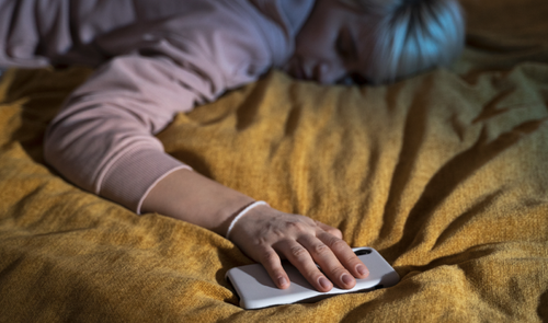 mujer con movil en la cama