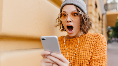 mujer sorprendida mirando movil