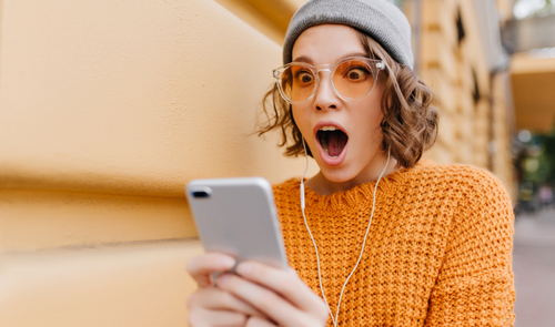 mujer sorprendida mirando movil