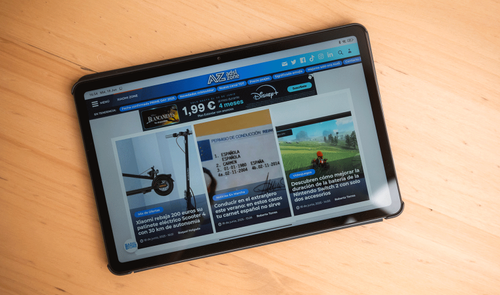 Tableta Redmi Pad 2 mostrando la portada del sitio web ADSLZone sobre una mesa de madera.