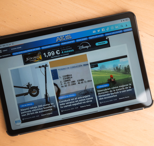 Tableta Redmi Pad 2 mostrando la portada del sitio web ADSLZone sobre una mesa de madera.