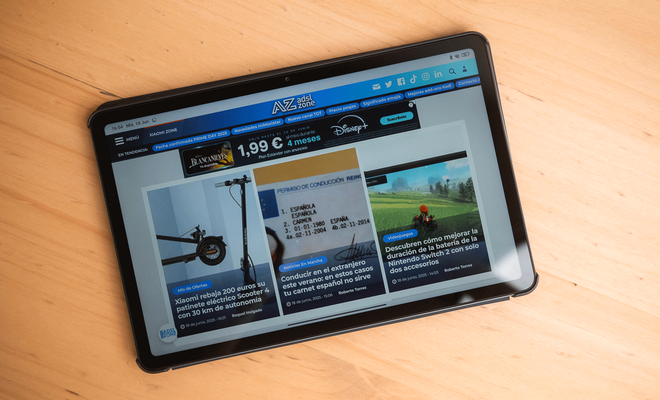 Tableta Redmi Pad 2 mostrando la portada del sitio web ADSLZone sobre una mesa de madera.