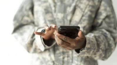 Soldado con smartphone en la mano.