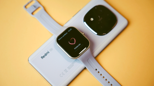 Reloj inteligente Redmi Watch 5 con correa azul claro mostrando la interfaz de medición de ritmo cardíaco sobre un teléfono móvil.