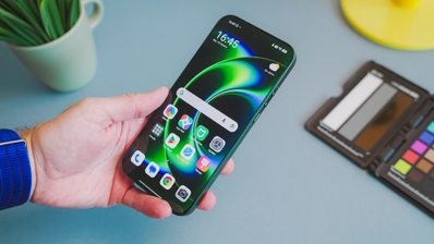 Primer plano de una mano sosteniendo el Xiaomi 17 Ultra con la pantalla encendida mostrando el menú de aplicaciones sobre un fondo de escritorio.