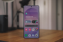 Primer plano del frontal del Samsung Galaxy S26 Ultra con la pantalla encendida mostrando widgets y aplicaciones sobre una mesa de madera.