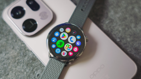 Reloj inteligente OPPO Watch X2 Mini con el menú de aplicaciones Wear OS sobre un teléfono móvil de la misma marca.