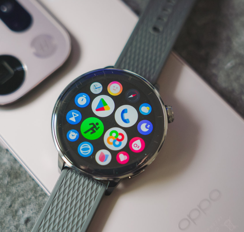 Reloj inteligente OPPO Watch X2 Mini con el menú de aplicaciones Wear OS sobre un teléfono móvil de la misma marca.