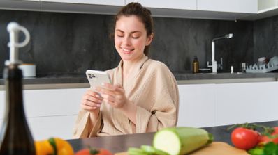 Mujer mirando el móvil frente a comida.