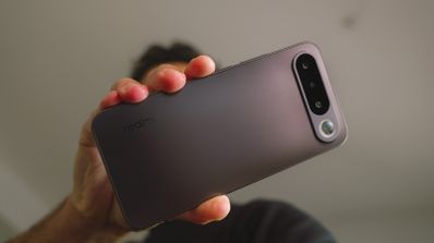 Mano sujetando el cuerpo trasero de un smartphone realme en color lavanda con módulo de cámara alargado.