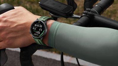 Reloj inteligente Xiaomi Watch S5 en la muñeca de un ciclista mientras sujeta el manillar de una bicicleta.