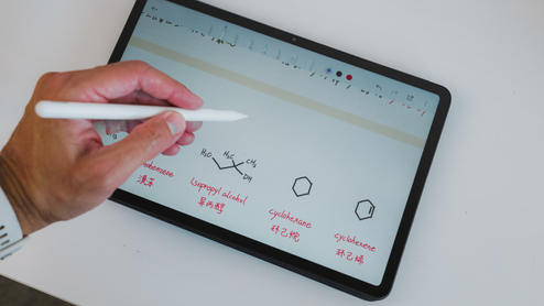 Mano utilizando un lápiz óptico sobre la pantalla de una tablet Redmi Pad 2 Pro con anotaciones de fórmulas químicas.