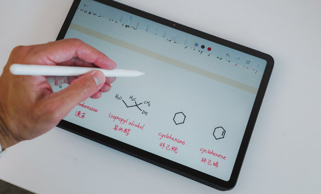 Mano utilizando un lápiz óptico sobre la pantalla de una tablet Redmi Pad 2 Pro con anotaciones de fórmulas químicas.