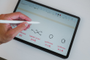 Mano utilizando un lápiz óptico sobre la pantalla de una tablet Redmi Pad 2 Pro con anotaciones de fórmulas químicas.