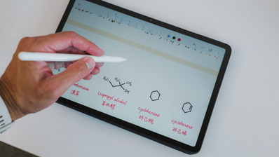 Mano utilizando un lápiz óptico sobre la pantalla de una tablet Redmi Pad 2 Pro con anotaciones de fórmulas químicas.